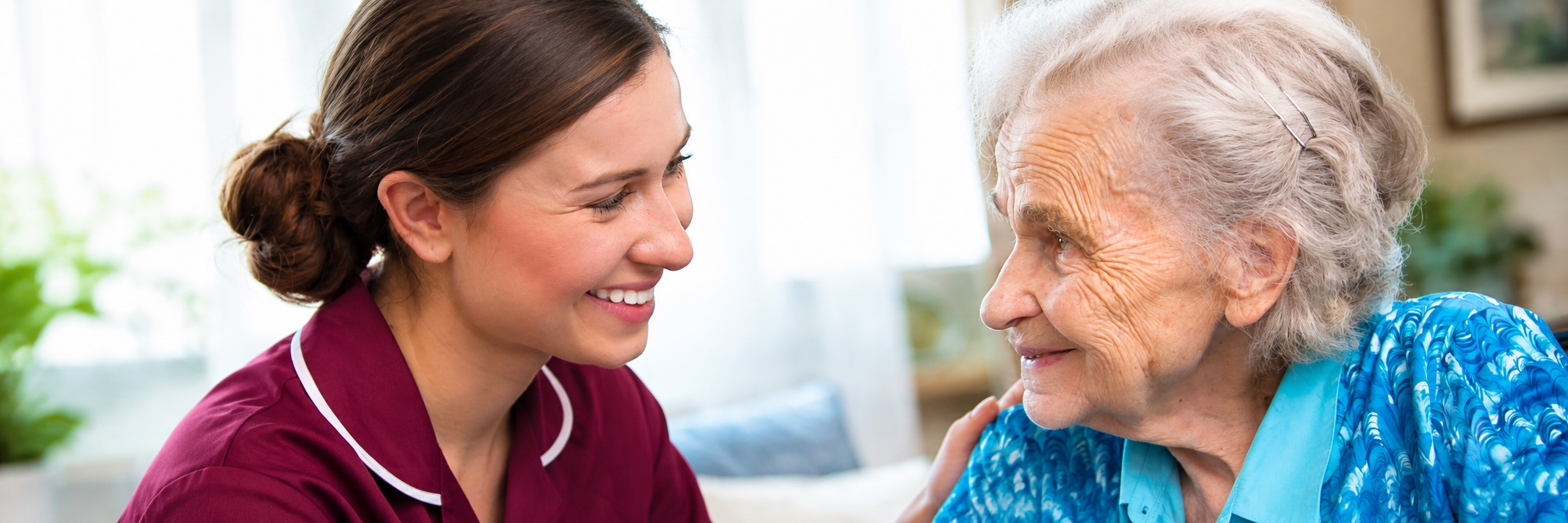 Caregiver sharing tea with elderly man in kitchen